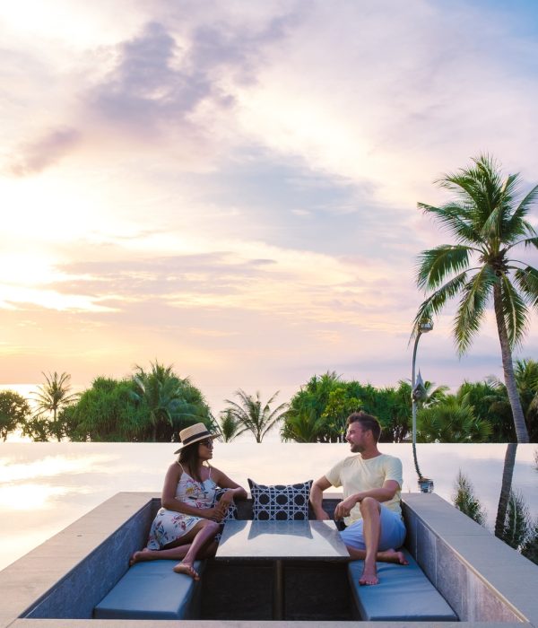 couple watching the sunset in an infinity pool on a luxury vacation in Thailand